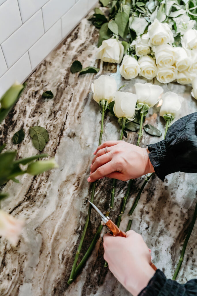 a florist cutting the ends off of flowers.
