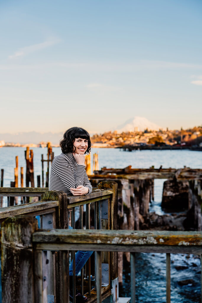 a photo of a women standing on a pier in front of Mt Rainer in Tacoma, WA
