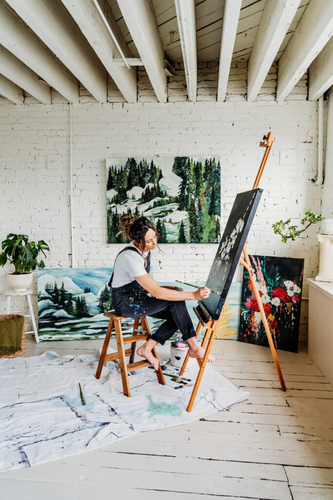a painter painting a bouquet of flowers on her canvas