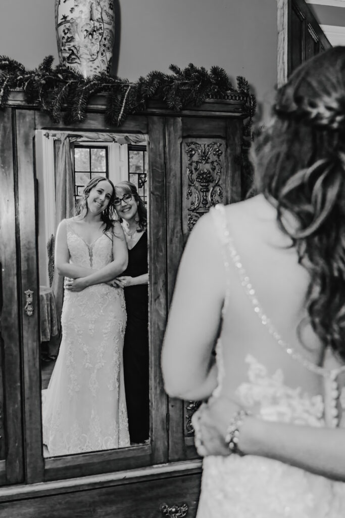 mom and daughter looking into the mirror on her wedding day